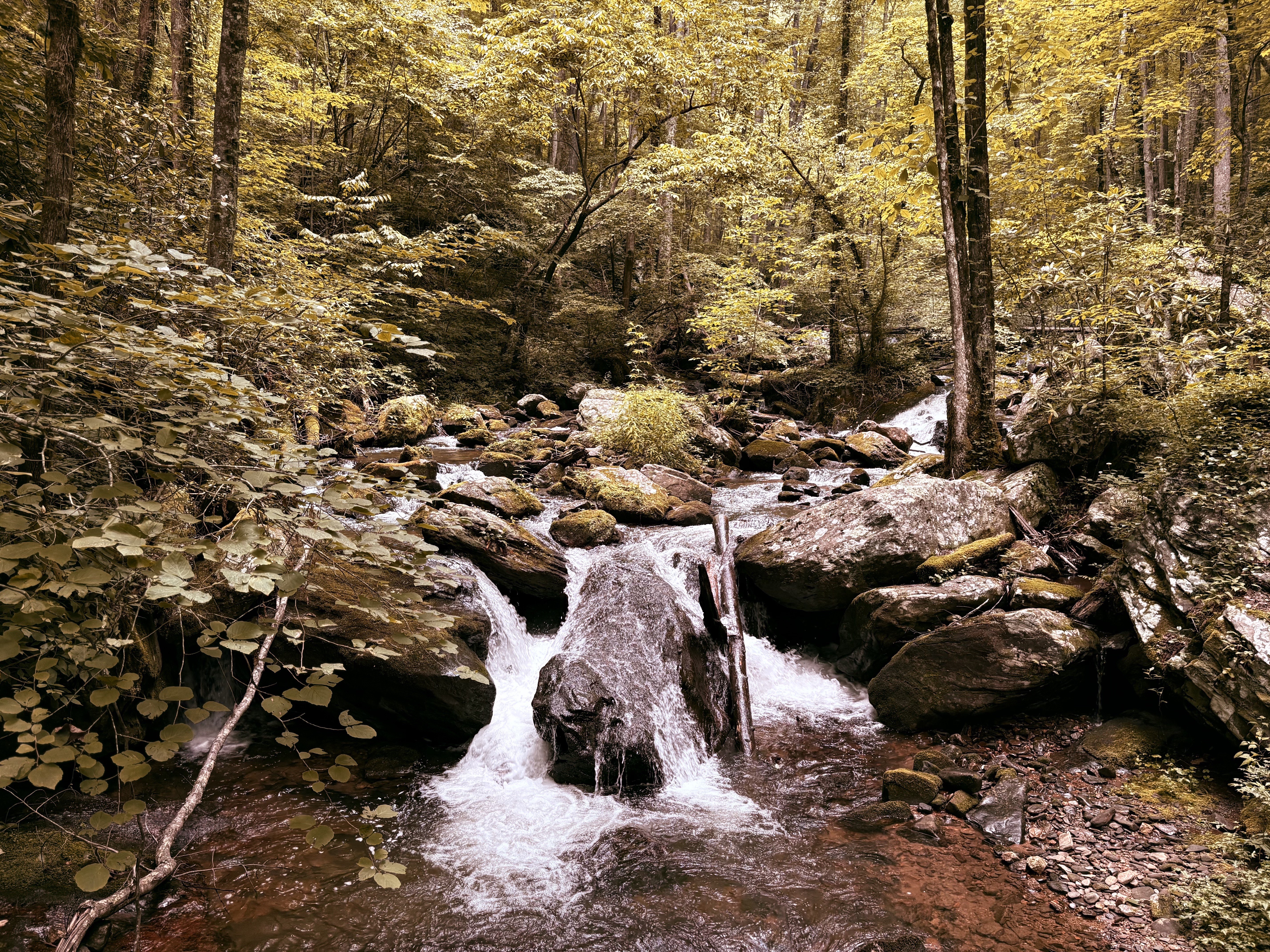 river flowing down small waterfall 